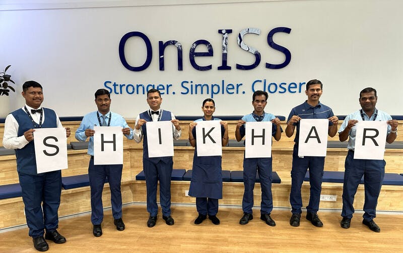 OneISS Group of people spelling out word crop