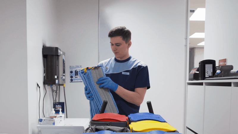 Man preparing trolley with mop cloths